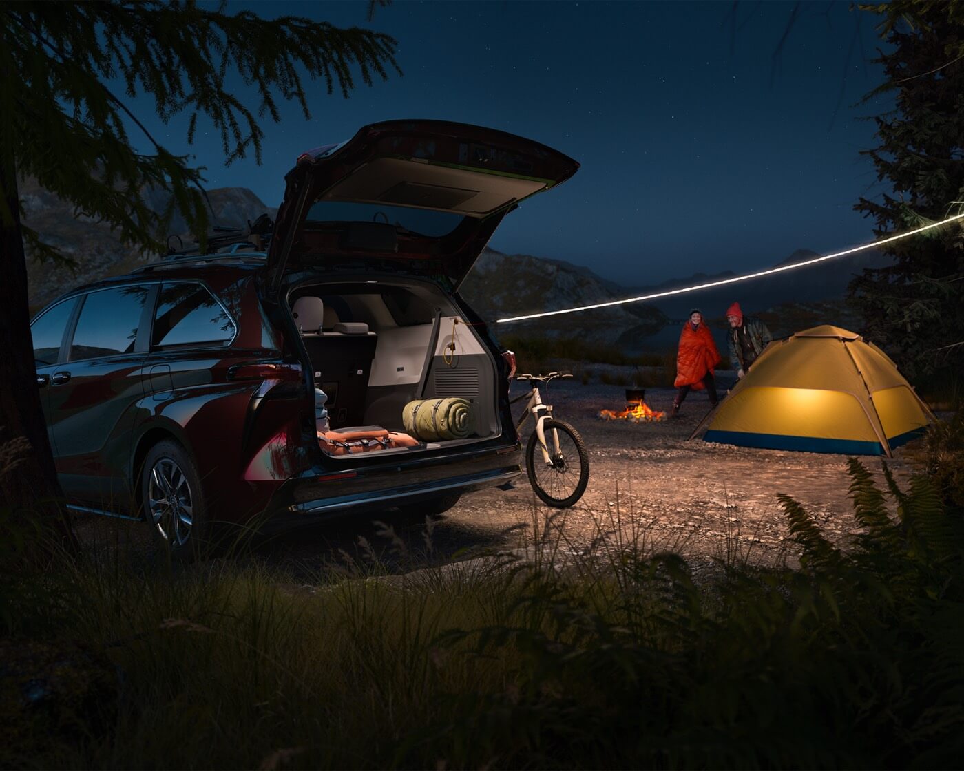 rear view of the 2022 Toyota Sienna with the trunk open on a camping site