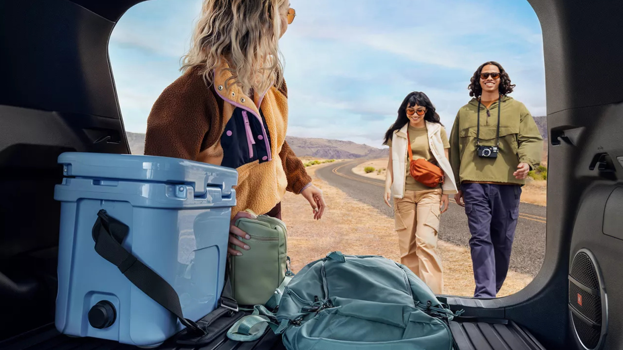 Coffre du Toyota Corolla Cross hybride 2026 avec une glacière et des bagages pour une sortie en plein air.