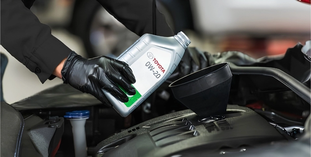 Engine oil being added to a Toyota vehicle during regular maintenance excluded from warranty coverage.