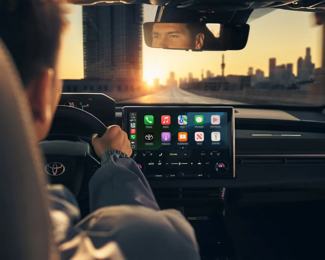 Driver at the wheel of a 2026 Toyota bZ with multimedia display, illustrating Toyota extended mechanical protection.