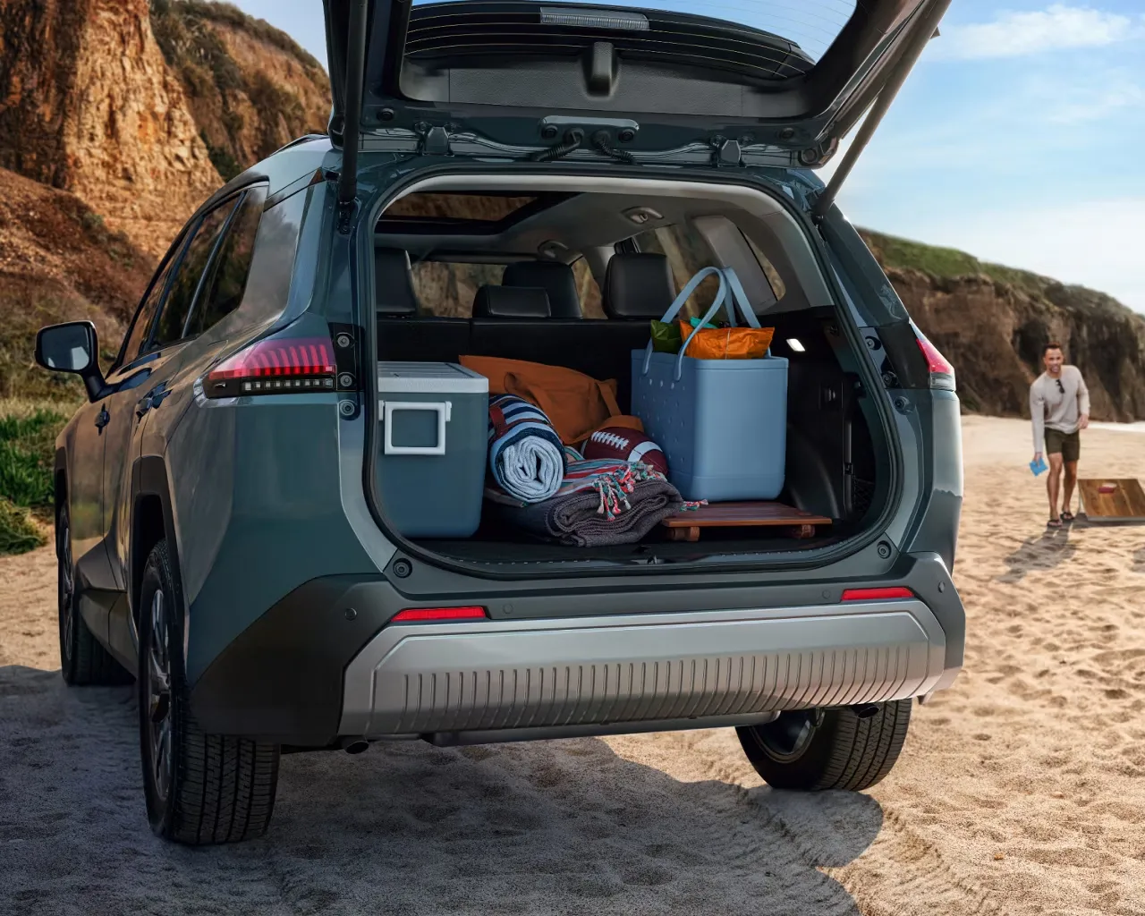 Coffre ouvert du Toyota RAV4 2026 chargé de glacières et de matériel de plage.